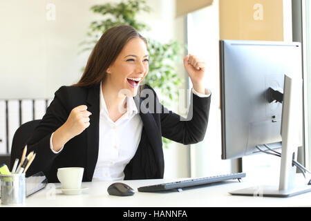 Aufgeregt Executive Anzug Arme gerade einen Desktop-Computer-Monitor im Büro Stockfoto