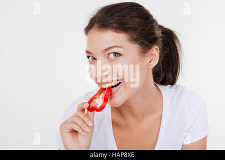 Porträt der glückliche junge Frau Gemüse essen. Isoliert auf weißem Hintergrund. Stockfoto