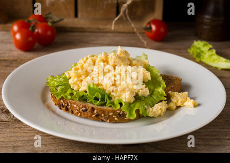 Frühstücks-Sandwich mit Rührei, frischer grüner Salat und Vollkornbrot. Nahaufnahme, horizontale Stockfoto