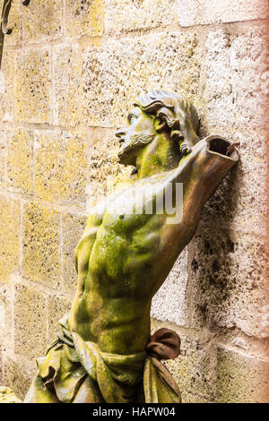 Eine Figur aus Jesus Christus sitzt durch eine Mauer in Saint Andoche Basilika in Saulieu, Frankreich. Stockfoto