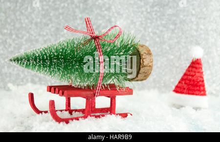 Rote Winter Schlitten tragen einen kleinen Weihnachtsbaum Stockfoto