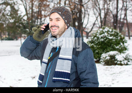 Barde Jüngling mit Handy im winter Stockfoto