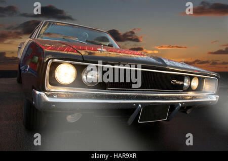 Schwarz Dodge Ladegerät von vorne Winkel mit Leuchten an mit Dramatischer Sonnenuntergang Stockfoto