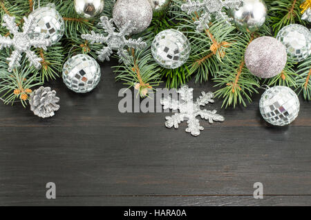 Silberne Weihnachtsschmuck und Tanne an der Wand hängen Stockfoto