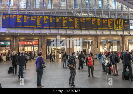 London, Menschen vor die elektronischen Tafeln mit Ankunft und Abreise Züge auf der Kings Cross Staatsbahn Stockfoto