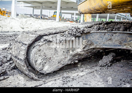 Nahaufnahme auf schmutzigen Crawler während der Bewegung durch Schlamm auf Baustelle. Stockfoto