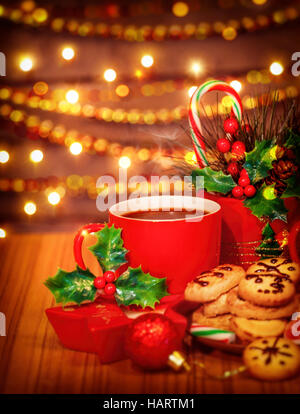 Frohe Weihnachten, Grußkarte, schöne gemütliche festliche Süßigkeiten Stillleben, leckere hausgemachte Kekse mit roten Tasse heißer Schokolade auf dem Holztisch Stockfoto