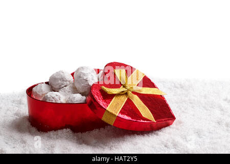 Traditionellen Weihnachtsplätzchen mit Mandeln in Herz-Form-Geschenk-Box auf Schnee Stockfoto