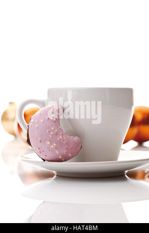 Kaffeetasse und Halbmond-förmige Lebkuchen, Weihnachtskugeln auf Rückseite Stockfoto