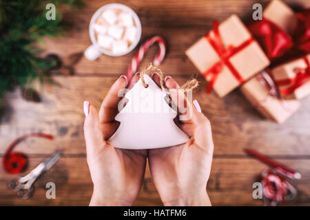 Kreative Hobby. Frauenhand zeigen Weihnachten Urlaub handgemachte Weihnachtsbaum Spielzeug. Schere auf Holztisch, Ansicht von oben. Winter Urlaub Konzept. Stockfoto
