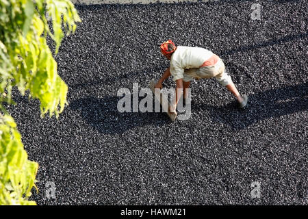 Mann Nivellierung Straße wird geteert bei Pune, Maharashtra, India Stockfoto