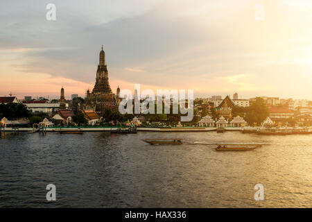 Wat Arun während Sonnenuntergang Woth Longtail-Boot im Chao Phraya River an der Stadt Bangkok, Thailand Stockfoto
