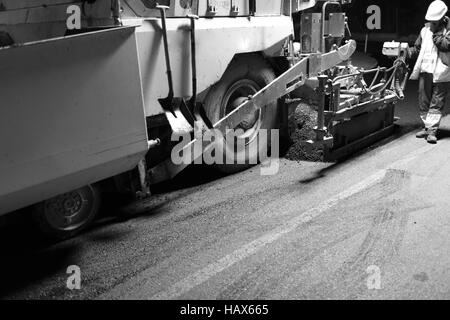 Pflaster-Maschine erweitern Asphalt in Nachtschicht Stockfoto