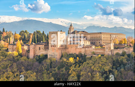 Alhambra - mittelalterliche maurische Festung, umgeben von gelb im Herbst Bäume mit Schneebergen im Hintergrund, Granada, Andalusien, Spanien Stockfoto