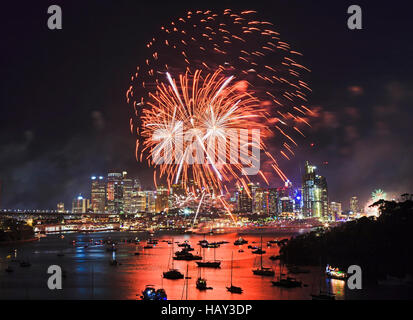 Rot leuchtend bunte Lichtkugeln über Stadt Sydney CBD während der jährlichen Silvester Feuerwerk-Licht-Show im Hafen Wasser reflektiert. Stockfoto