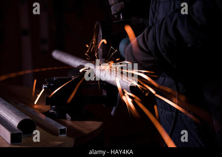 Arbeiter Schleifen Metallrohr mit einer Maschine in der Werkstatt Stockfoto