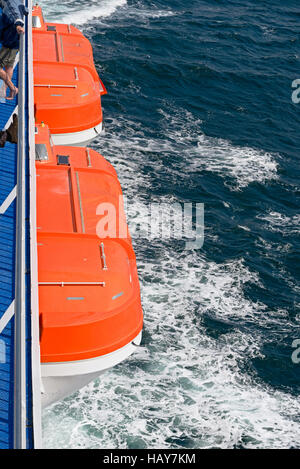 Zwei orange Rettungsboote auf einer Fähre am Meer Stockfoto