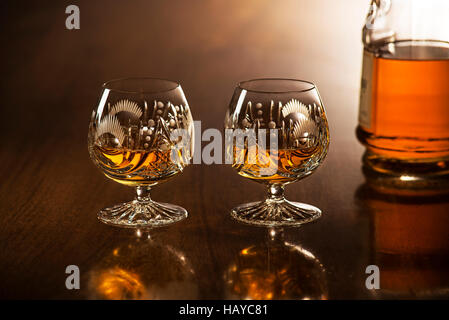 Cognac im Glas mit Flasche auf Holztisch Stockfoto