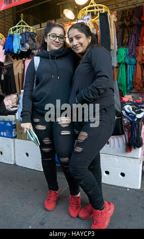 Zwei Jugendliche, die fast identisch in Chinatown, Downtown Flushing, New York City gekleidet sind. Stockfoto