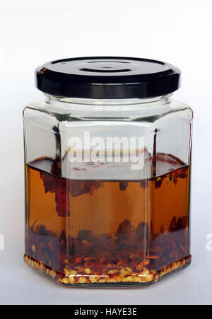 Chiliöl in Glas Stockfoto