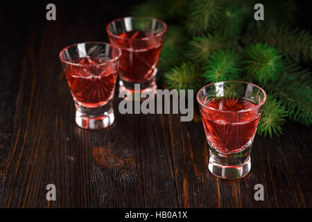 Weihnachten mit Preiselbeeren auf hölzernen Hintergrund, mit Tannenzweigen alkoholische Erfrischungsgetränk