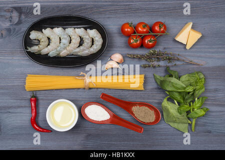 Holzlöffel und Zutaten auf dunklem Hintergrund. Vegetarische Kost, Gesundheit oder Koch-Konzept. Stockfoto