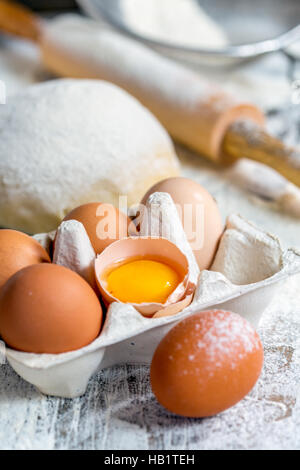 Tablett mit Eiern, Teig und Nudelholz. Stockfoto