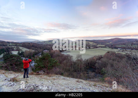 Ein Fotograf fängt den Sonnenaufgang über eine gefrorene Landschaft über die Weiler von Haaren in Flintshire mit dem Clwydian in der Ferne Stockfoto