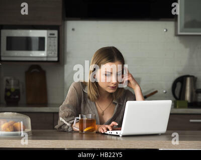 2. Dezember 2016 - junge schöne kaukasischen Frau Drinkig Tee und sieht Informationen im Bereich social Media auf Net-Book © Golovniov/ZUMA Igor Draht/Alamy Live News Stockfoto