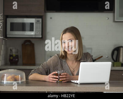 2. Dezember 2016 - junge schöne kaukasischen Frau Drinkig Tee und sieht Informationen im Bereich social Media auf Net-Book © Golovniov/ZUMA Igor Draht/Alamy Live News Stockfoto