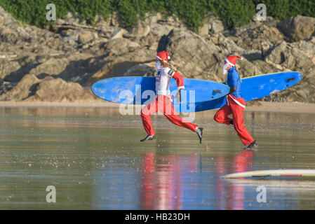 Newquay, Großbritannien. 04 Dez, 2016. Fistral Beach, Newquay, Cornwall. 4. Dezember 2016. Surfen Weihnachtsmänner Rennen zu Beginn der Geldbeschaffung Santa Surfen Wettbewerb auf einem sehr kühl Fistral Beach in Newquay, Cornwall. UK. Fotograf Credit: Gordon Scammell/Alamy leben Nachrichten Stockfoto