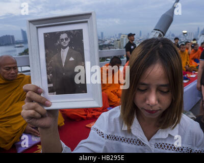 Bangkok, Bangkok, Thailand. 5. Dezember 2016. Eine Frau hält ein Porträt des verstorbenen Königs, während sie während einer Zeremonie zu Ehren seiner Majestät Bhumibol Brücke betet. Zehntausende von Thais versammelten sich auf Bhumibol Brücke in Bangkok Montag bis den Tod von Bhumibol Adulyadej, der spät König von Thailand zu trauern. Der König starb am 13. Oktober nach einem längeren Krankenhausaufenthalt. 5 Dezember ist Geburtstag und ein nationaler Feiertag in Thailand. Die Brücke ist nach dem späten König benannt, der den Bau berechtigt. 990 buddhistische Mönche beteiligte sich an ein besonderes Verdienst machen Zeremonie auf der Brücke. (Bild Kredit: Stockfoto