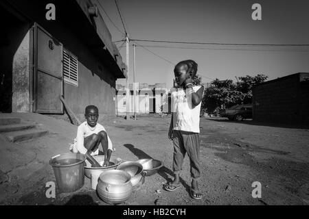 BAMAKO, MALI, Dez 23: Zwei afrikanische einheimische junge Mädchen den Abwasch außerhalb des Hauses in die Wohn Distrikt von Bamako. Mali 2010. Schwarz und Stockfoto