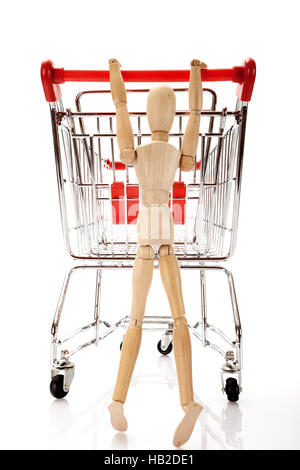 Gegliederte Holzfigur ein Einkaufswagen schieben Stockfoto