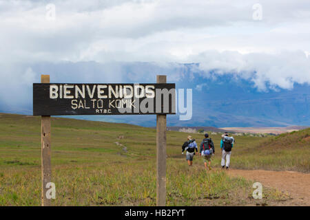 MOUNT RORAIMA, VENEZUELA, 31.März: Eingang Holz Schild mit der Aufschrift Willkommen bei Salto Komik ", Canaima-Nationalpark. Im Hintergrund drei Wanderer zu Fuß, Stockfoto