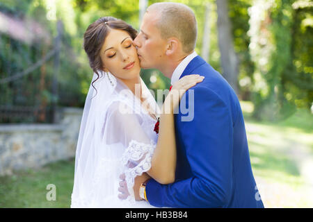 Der Bräutigam küsst die Braut auf die Wange Stockfoto
