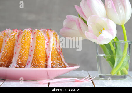 Gugelhupf mit Zuckerguss und Tulpen Stockfoto