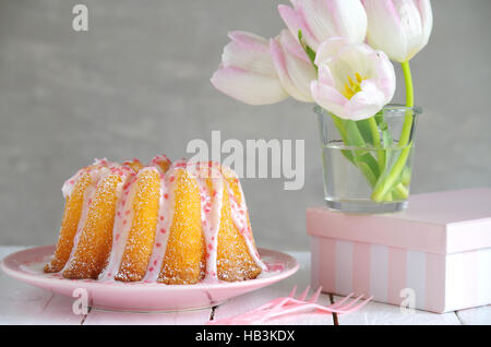 Gugelhupf mit Zuckerguss und Tulpen Stockfoto