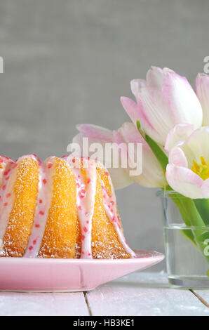 Gugelhupf mit Zuckerguss und Tulpen Stockfoto