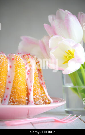 Gugelhupf mit Zuckerguss und Tulpen Stockfoto