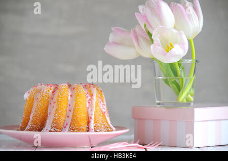 Gugelhupf mit Zuckerguss und Tulpen Stockfoto