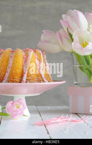 Gugelhupf mit Zuckerguss und Tulpen Stockfoto