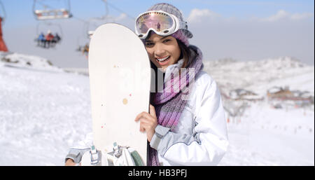 Junge Frau mit ihrem Snowboard lachen Stockfoto