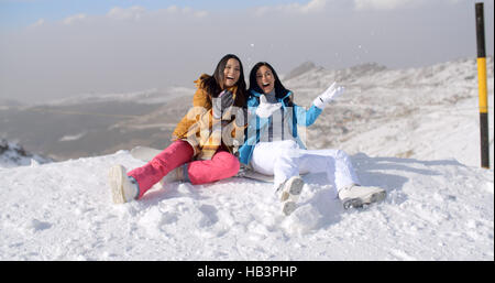 Zwei junge Frauen tummeln im Schnee Stockfoto