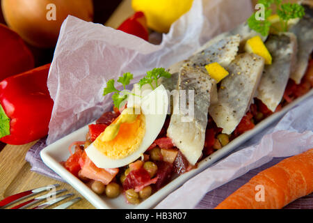 Gesalzener Hering mit Salat auf dem Tisch. Stockfoto