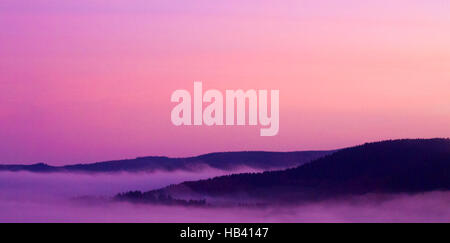 Berge unter Nebel am Morgen. Stockfoto