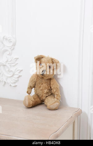 Retro-Teddybär Spielzeug allein auf weißen Schrank gegenüber weißen Hintergrund Stockfoto