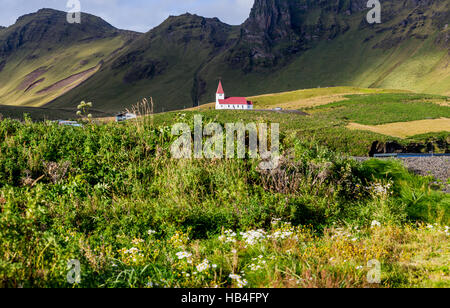 Weiße Kirche mit rotem Dach auf einem Hügel im Süden Islands. Stockfoto