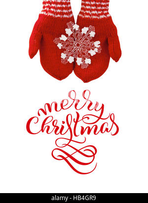 Frau Hand in rote Handschuhe eine Spielzeug-Schneeflocke mit Text Frohe Weihnachten. Kalligraphie-Schriftzug Stockfoto