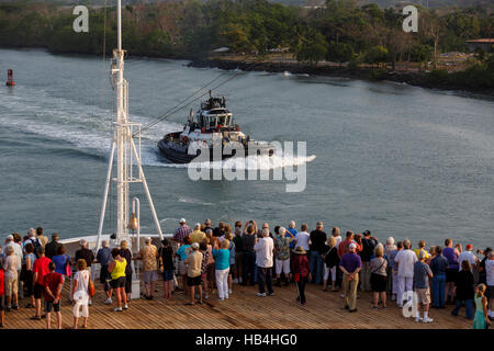 Kreuzfahrtschiff Passagiere an Deck zusehen, wie eine Panama Canal tugboat vorbei Stockfoto